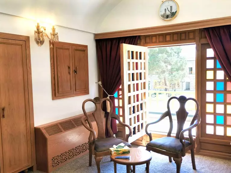 صندلی‌های چوبی اتاق کاروانیکا کنار درهای باز