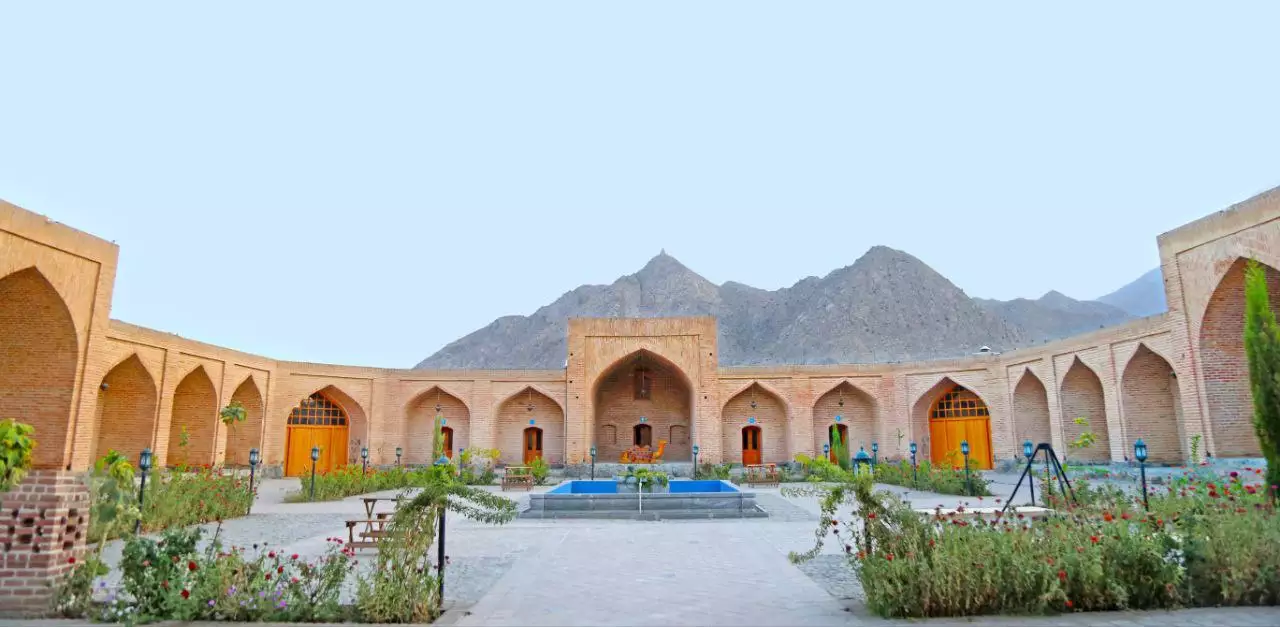 حیاط آجری هتل کوهاب با حوض و کوهستان