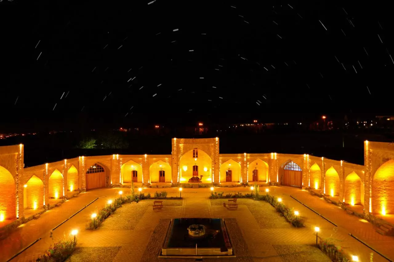 حیاط نورپردازی‌شده هتل کوهاب زیر آسمان شب