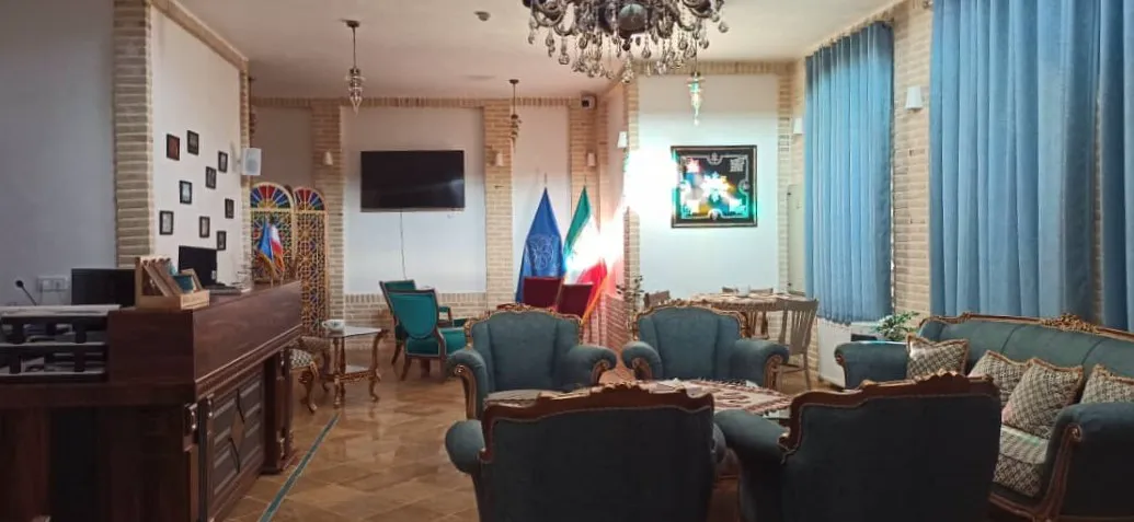 مبلمان آبی و میزهای چوبی در فضای نشیمن هتل افصح الدوله