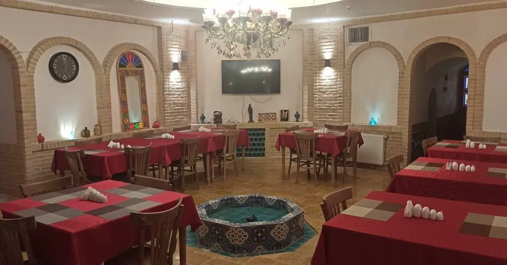سالن غذاخوری با میزهای قرمزرنگ هتل افصح الدوله