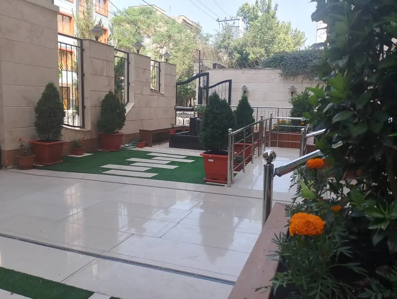 حیاط هتل سرای نور با مسیر سنگفرش و گلدانها