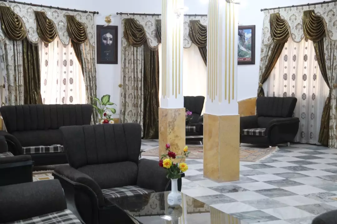 سالن نشیمن هتل شهرداری با مبل‌های مشکی و کف سنگی