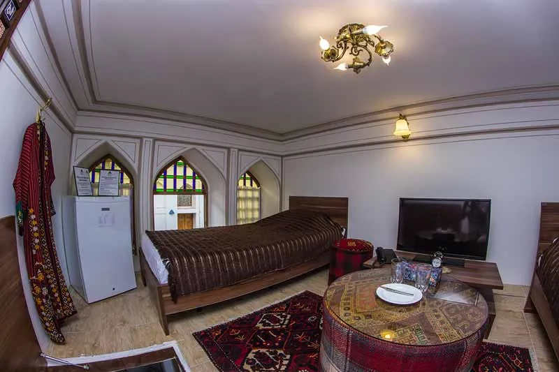 اتاق نشیمن هتل کیانپور با تخت و میز گرد