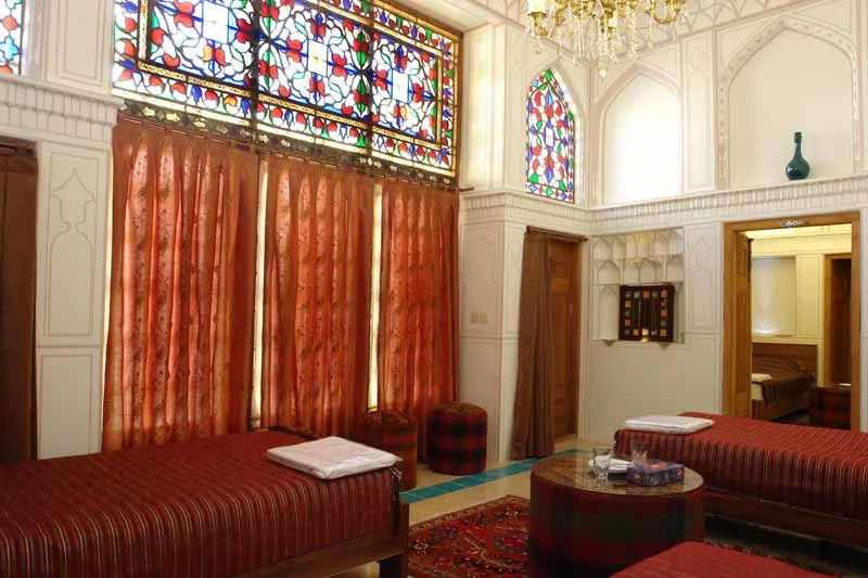 نشیمن هتل کیانپور با شیشه‌های رنگی و تخت‌های سنتی