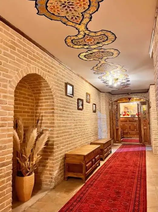 راهروی آجری با فرش قرمز و سقف نقاشی‌شده