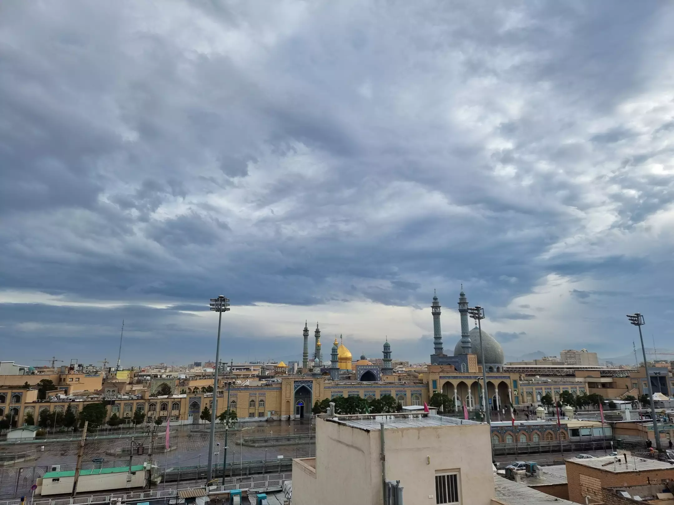نمای گنبد و مناره‌های حرم در آسمان ابری