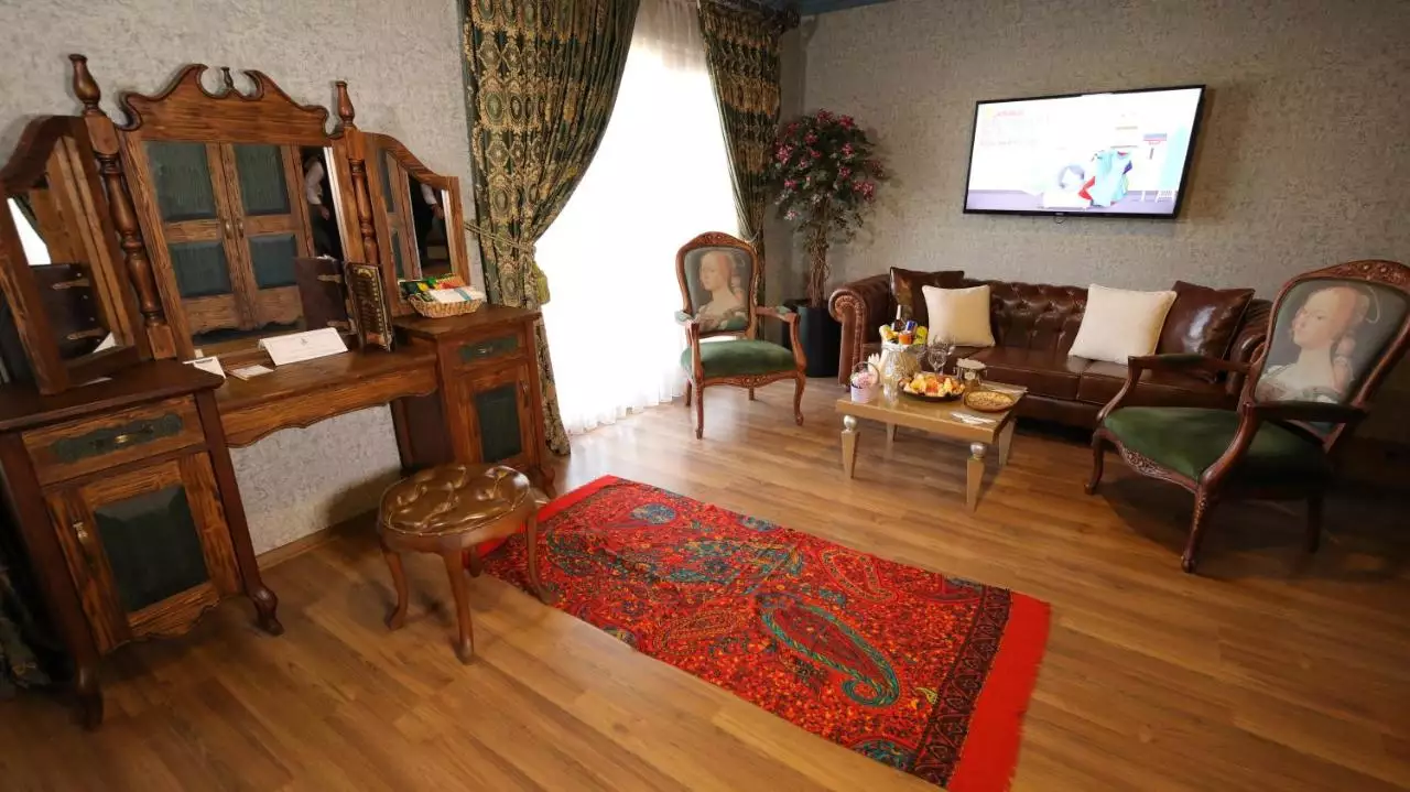 اتاق نشیمن هتل ریفرم با مبلمان چرمی و فرش قرمز