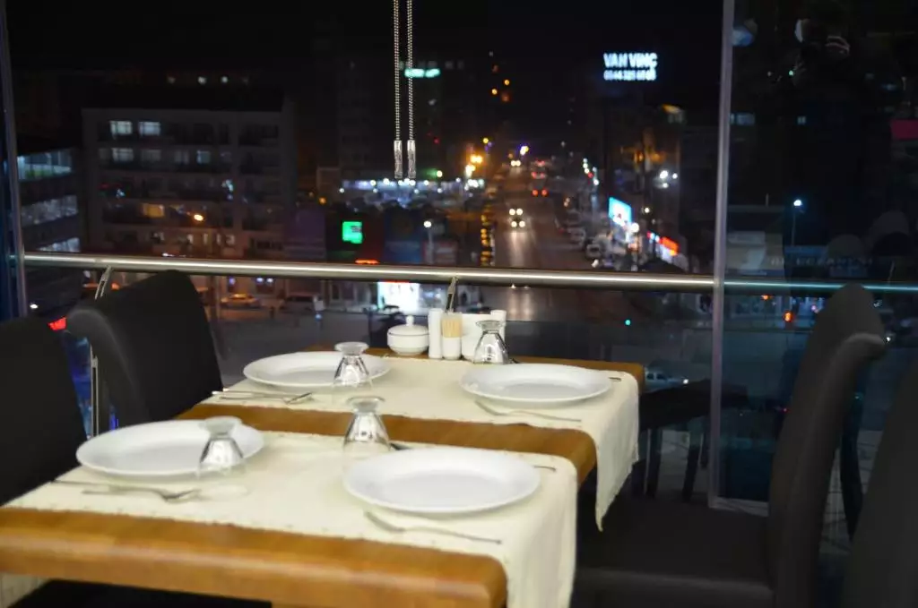 میز غذاخوری کنار پنجره با نمای شبانه شهر در گرند