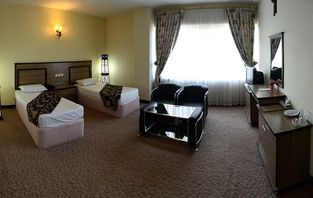 اتاق هتل بزرگ با دو تخت و فضای نشیمن