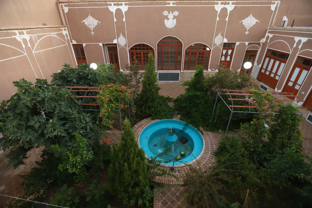 حیاط سرسبز کوچه حنا با حوض مرکزی