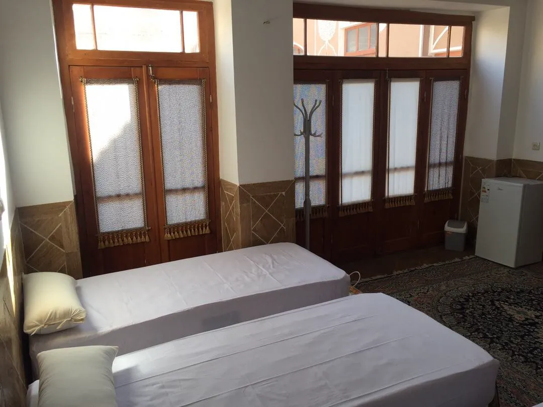 دو تخت اتاق کوچه حنا کنار پنجرههای چوبی