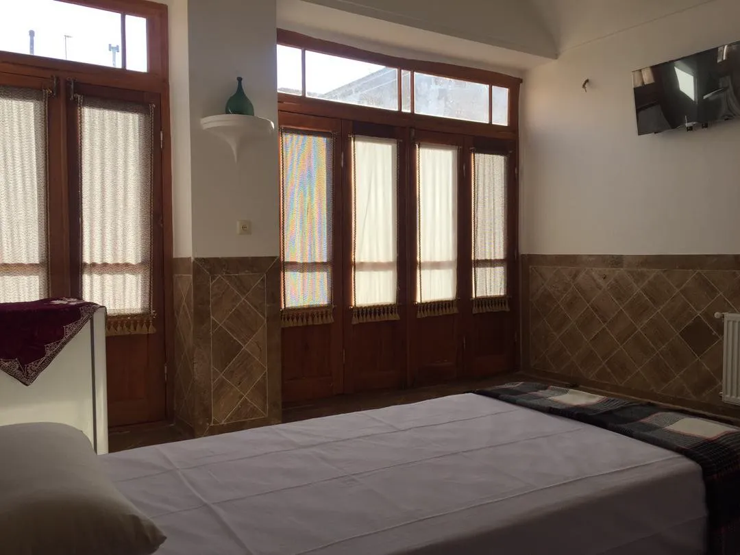 تخت اتاق کوچه حنا کنار پنجرههای چوبی