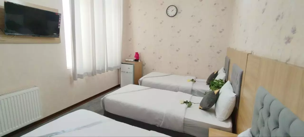 تخت‌های یک‌نفره کنار پنجره در هتل آراسته