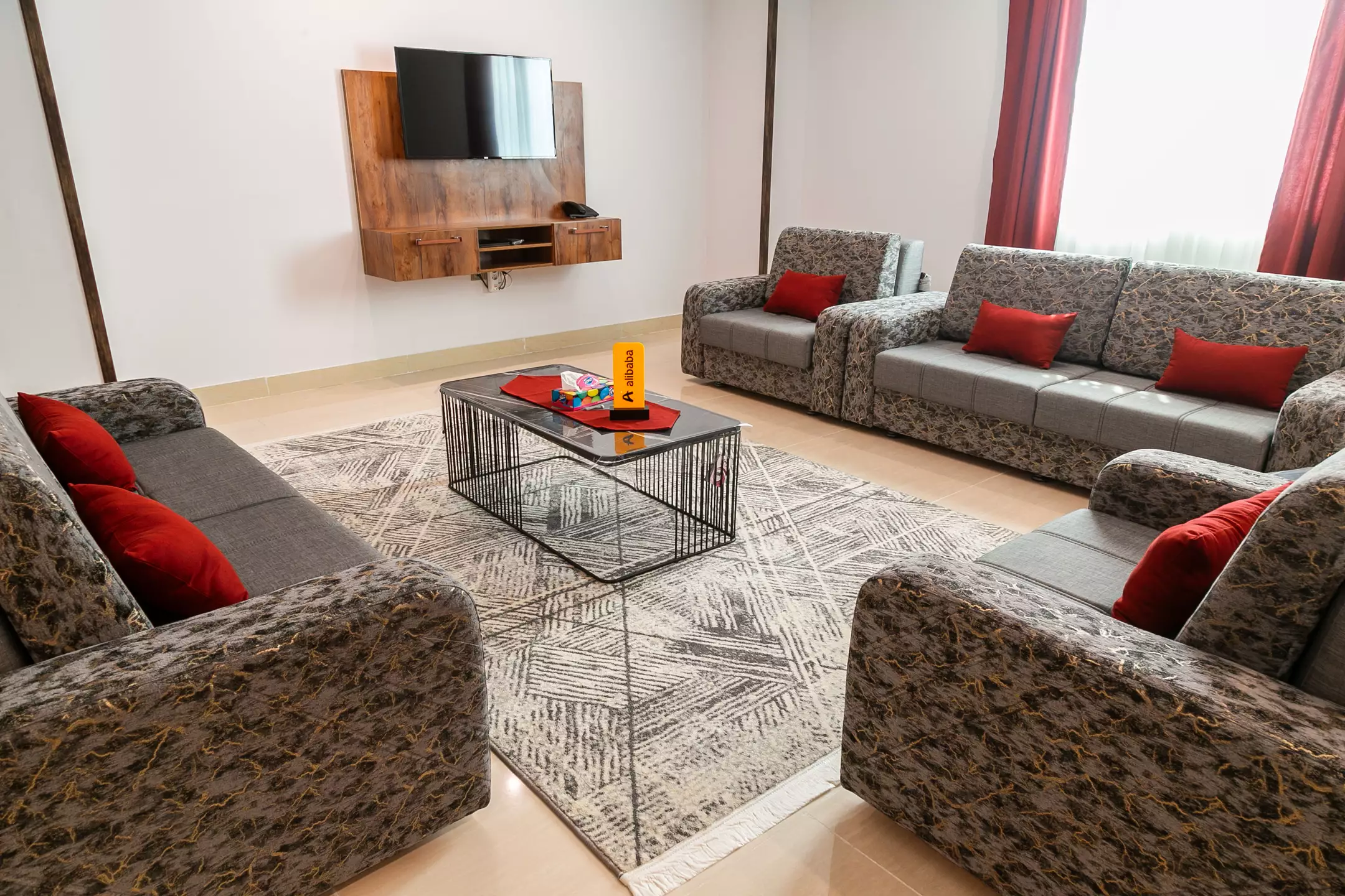 اتاق نشیمن هتل الیت با مبل‌های خاکستری و فرش هندسی