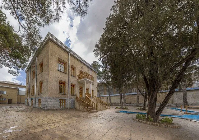 نمای بیرونی عمارت سنتی آریو در میان درختان