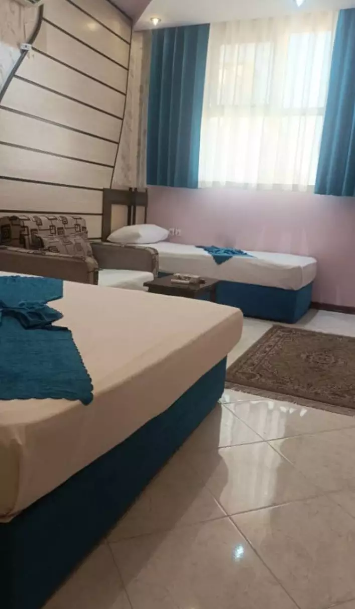 اتاق هتل میهمان با دو تخت و پرده آبی