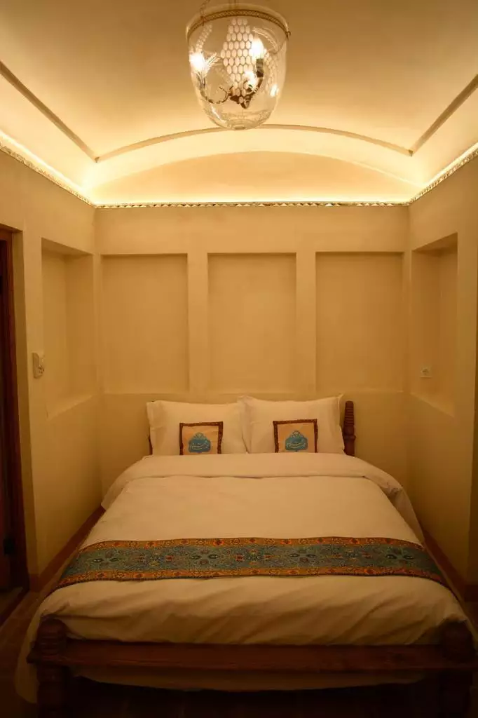 تخت دونفره در اتاق عمارت محمودیه با چراغ سقفی