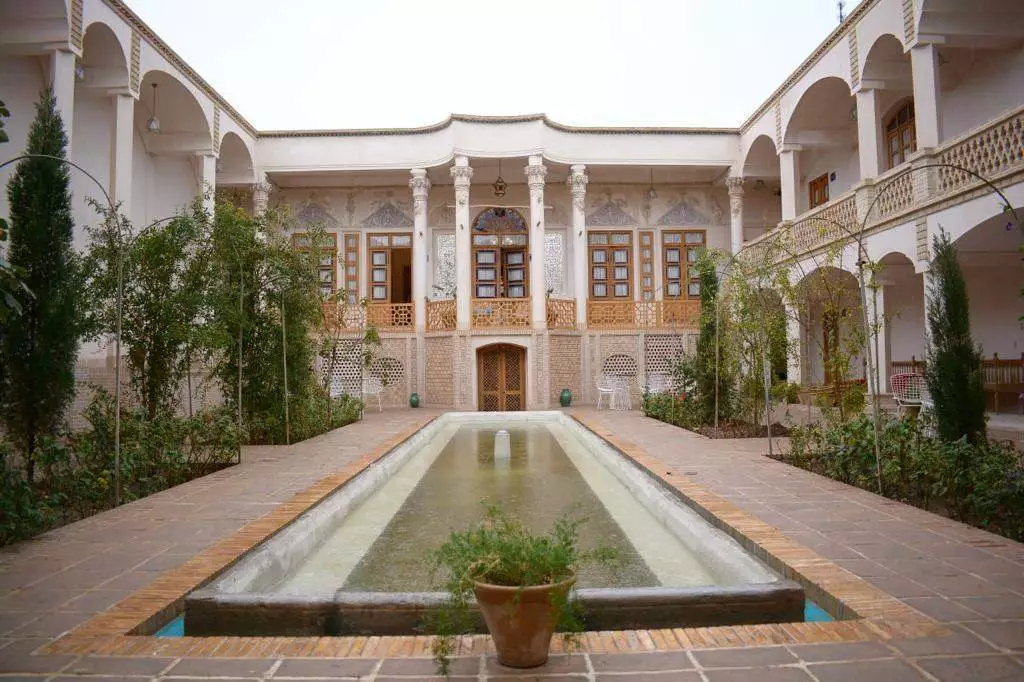 حیاط عمارت محمودیه با حوض مستطیلی و ایوان‌های ستون‌دار