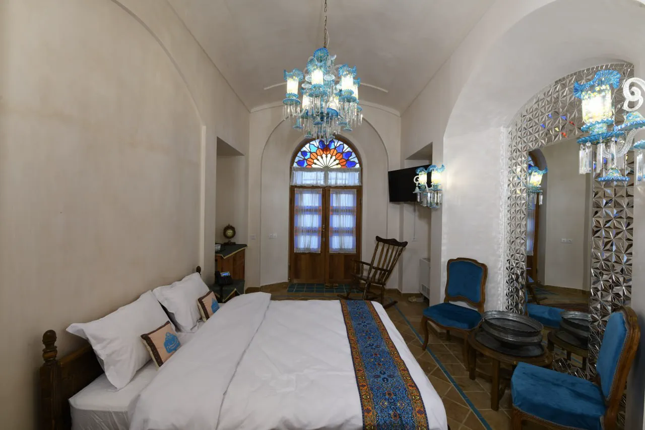 تخت دونفره و پنجره رنگی اتاق عمارت محمودیه