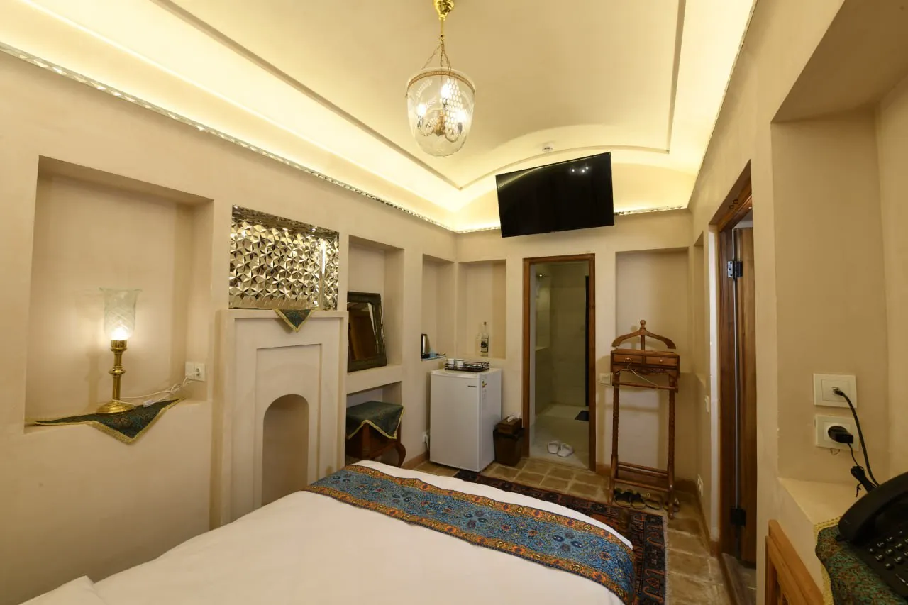 تخت دونفره و تلویزیون در اتاق عمارت محمودیه