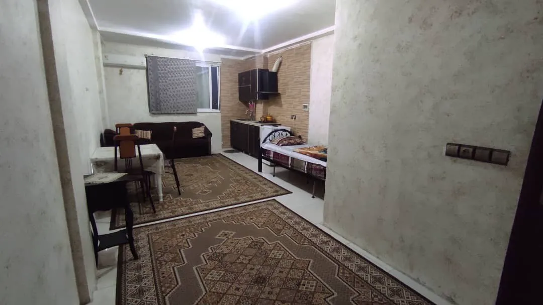 اتاق گل یاس با تخت، میز و فرش‌های طرح‌دار