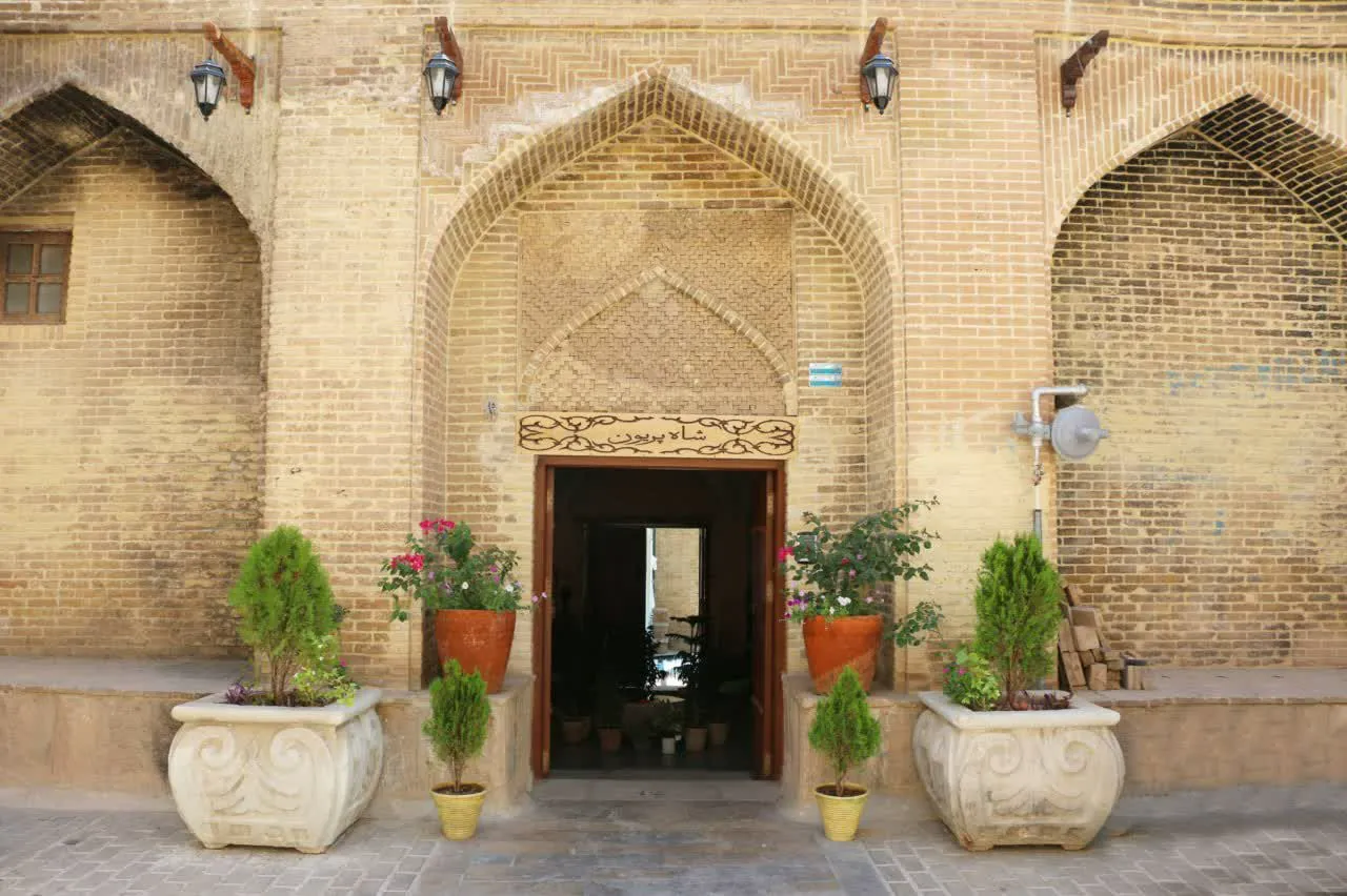 ورودی آجری هتل شاه پریون با گلدان‌های تزئینی
