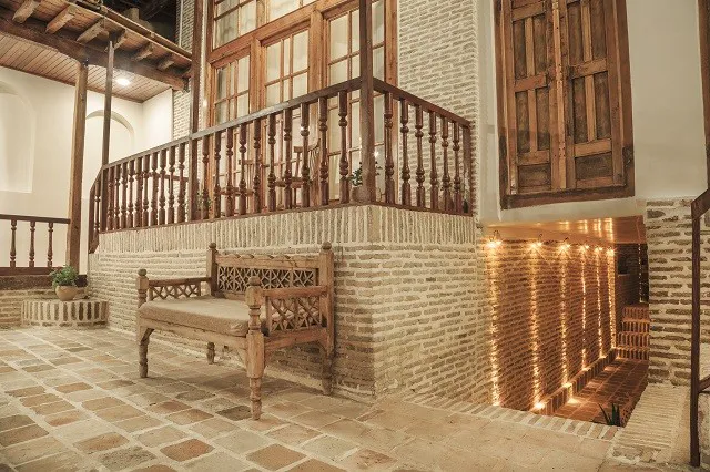 نیمکت چوبی در فضای آجری سرای خان
