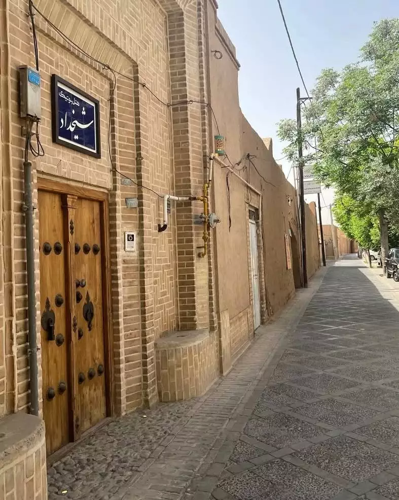 نمای ورودی هتل شیخداد در کوچه‌ای آجری