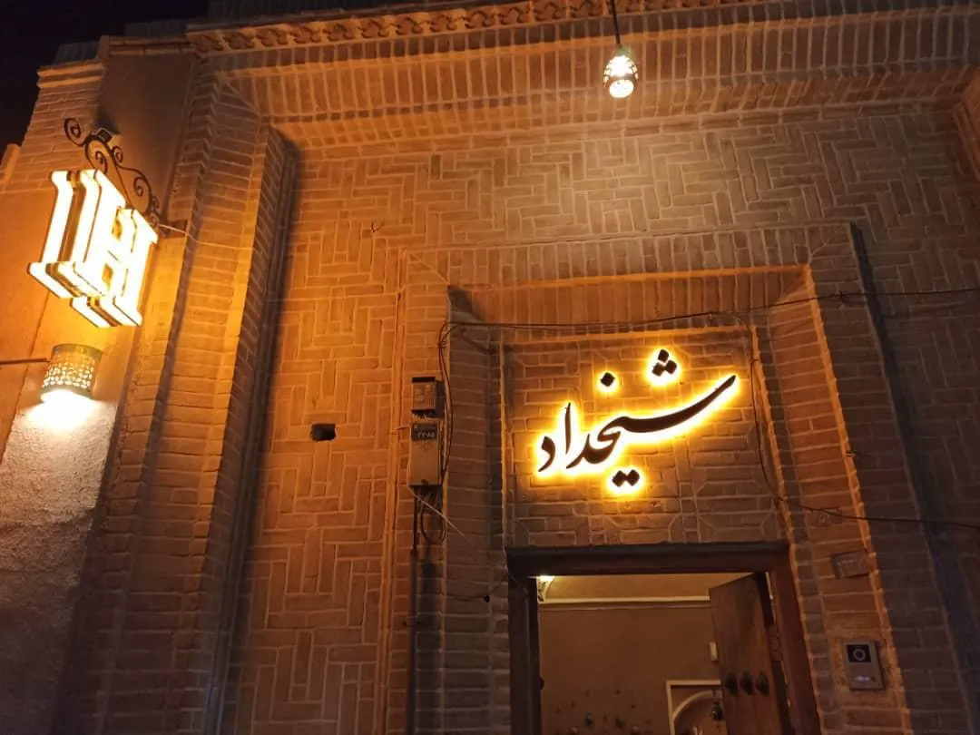 تابلوی ورودی هتل شیخداد در نمای آجری شب