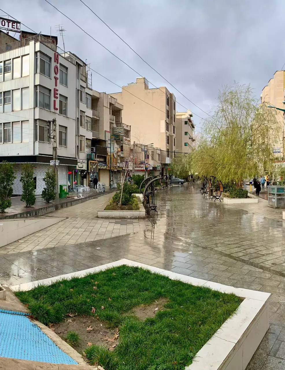 نمای بیرونی هتل راه کربلا در کنار پیاده‌راهی خیس