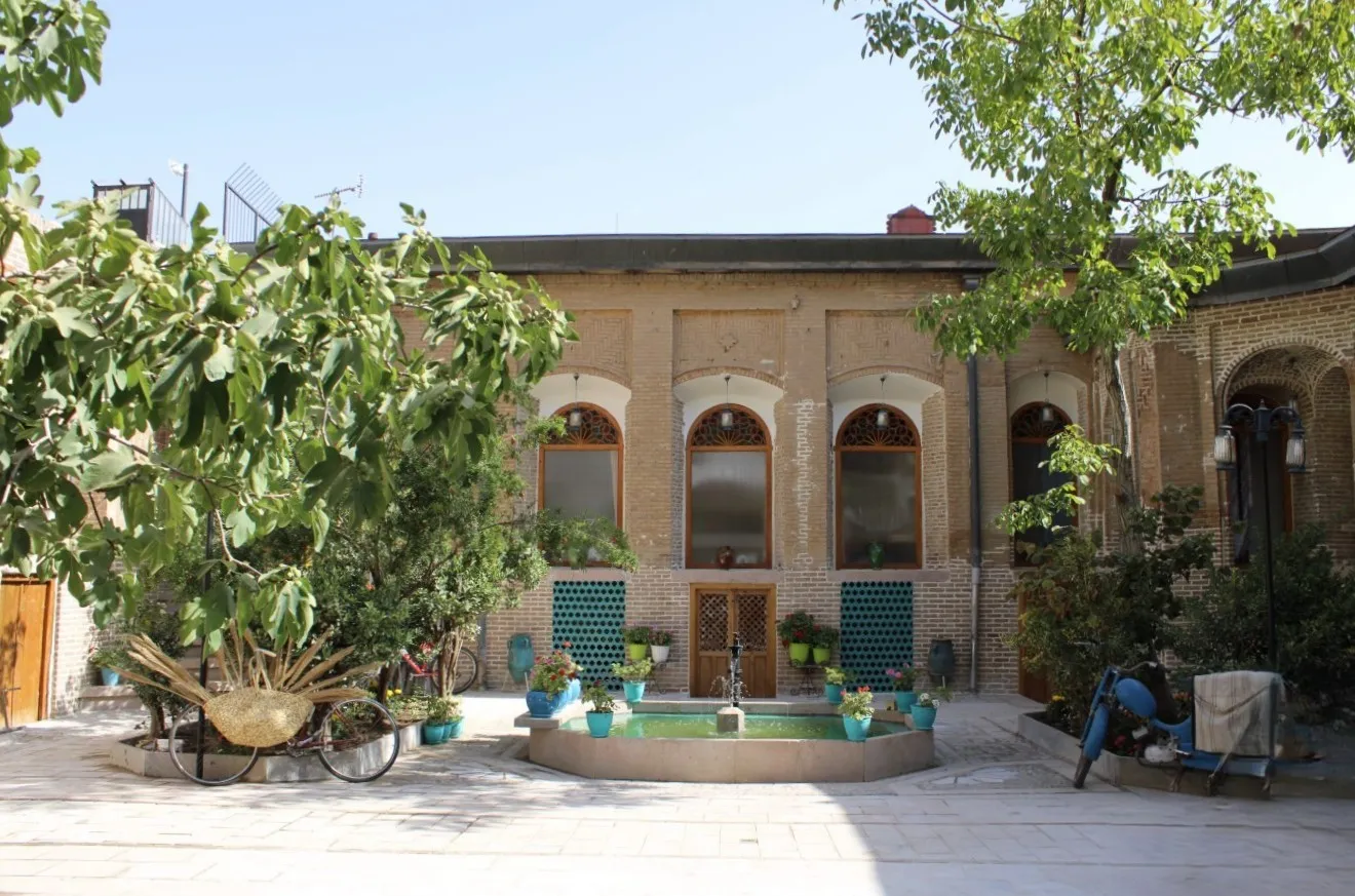 حیاط هتل نبوی با حوض و بنای آجری