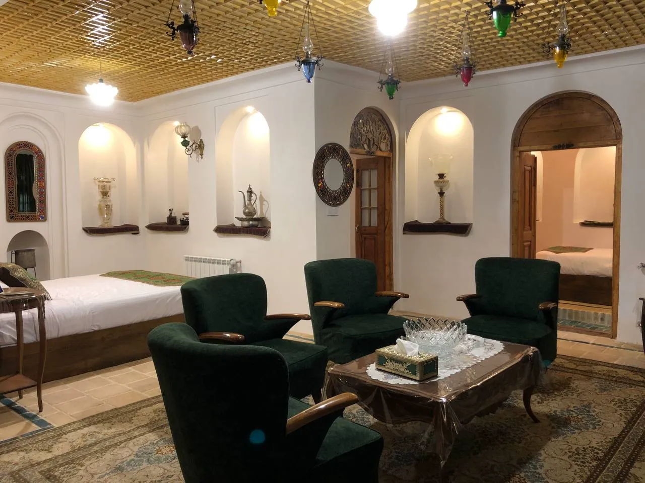 اتاق نشیمن هتل نبوی با مبلمان سبز و تخت