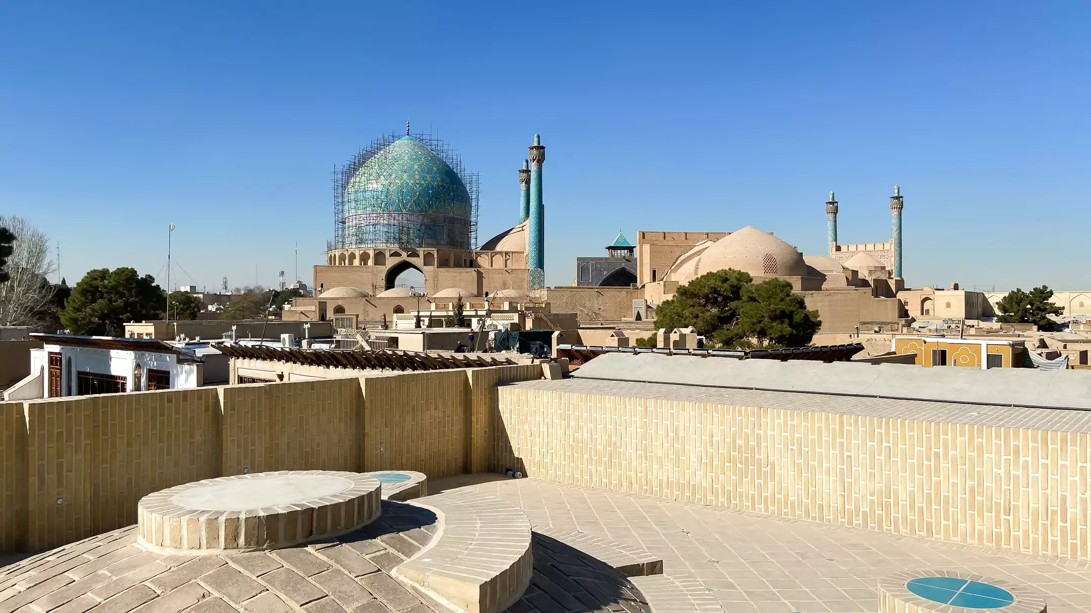 نمای گنبد فیروزهای مسجد در کنار هتل دالان جهان