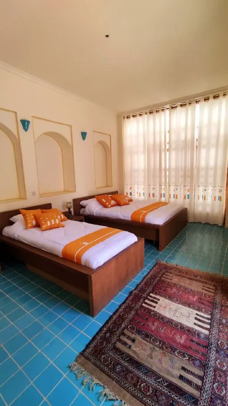 اتاق دالان جهان با دو تخت یکنفره و فرش