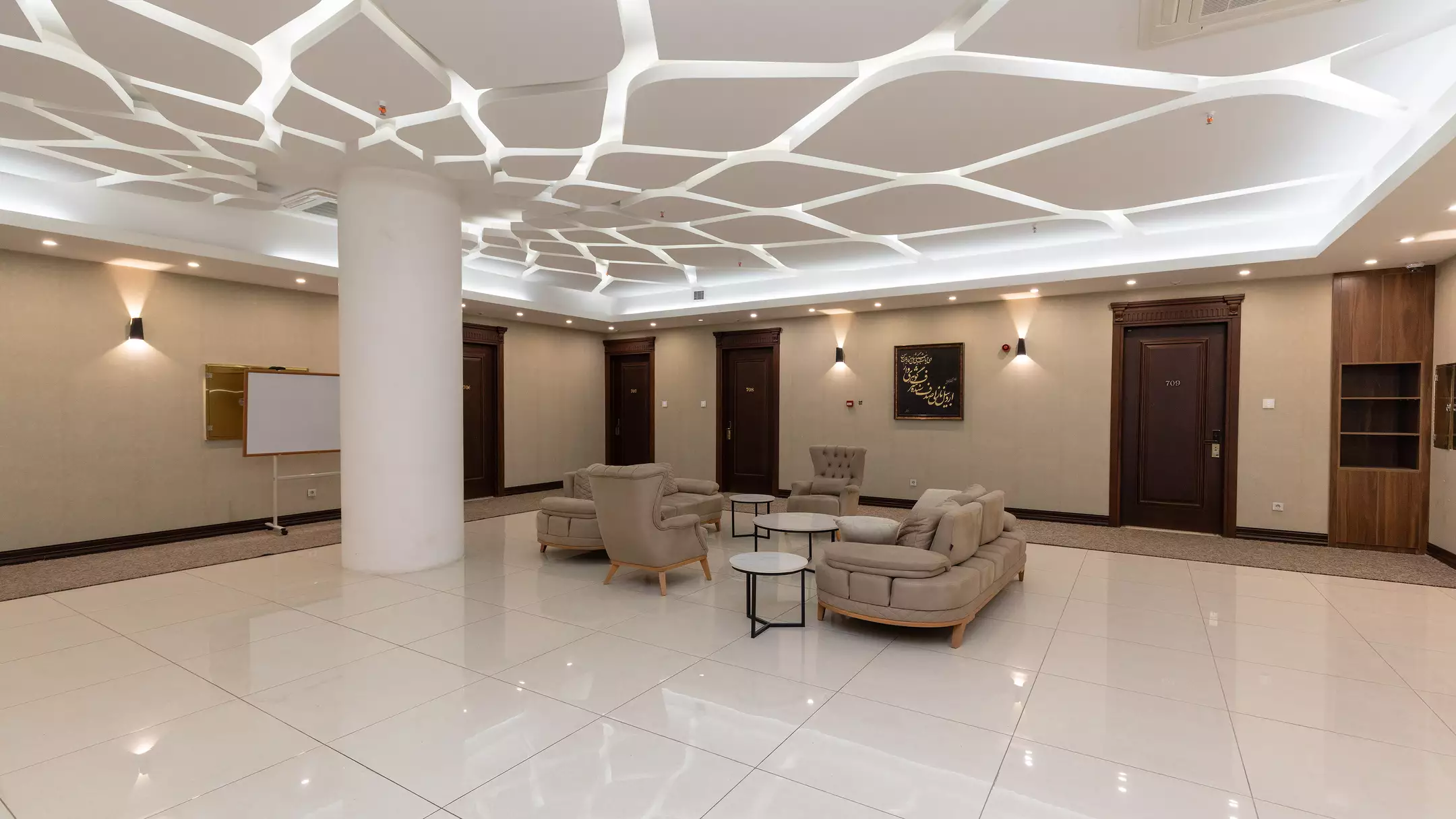 لابی ملل با نشیمن‌های خاکستری و سقف هندسی