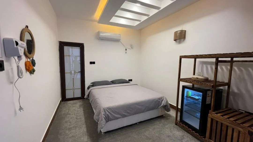 تخت دونفره و یخچال نوشیدنی در اتاق هتل ستاره خلف