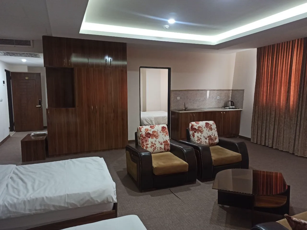 اتاق هتل اسکار با تخت، نشیمن و کابینت چوبی