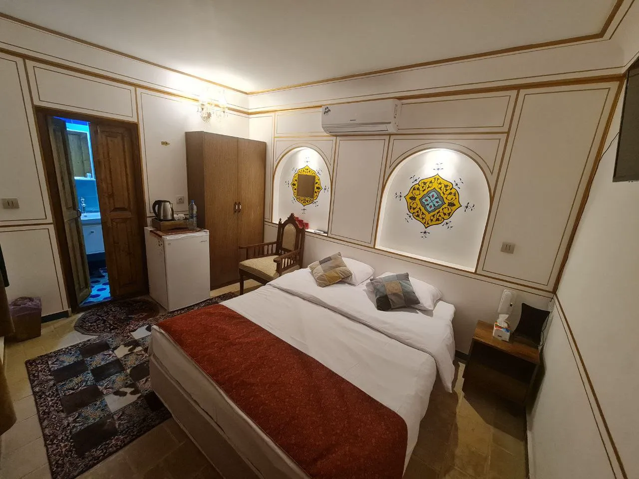 اتاق خواب عمارت طاووسیه با تخت دونفره و تزیینات دیواری
