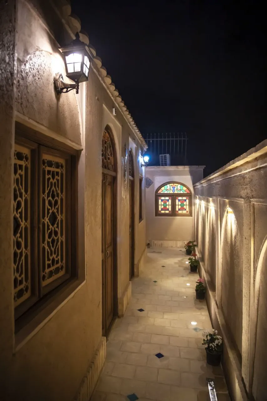 راهروی سنگفرش عمارت طاووسیه با پنجره رنگی در شب