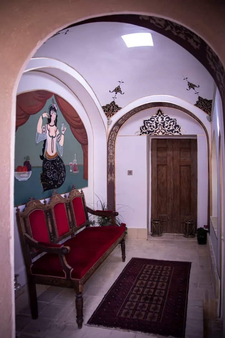 نشیمن عمارت طاووسیه با مبل سرخ و نقاشی دیواری