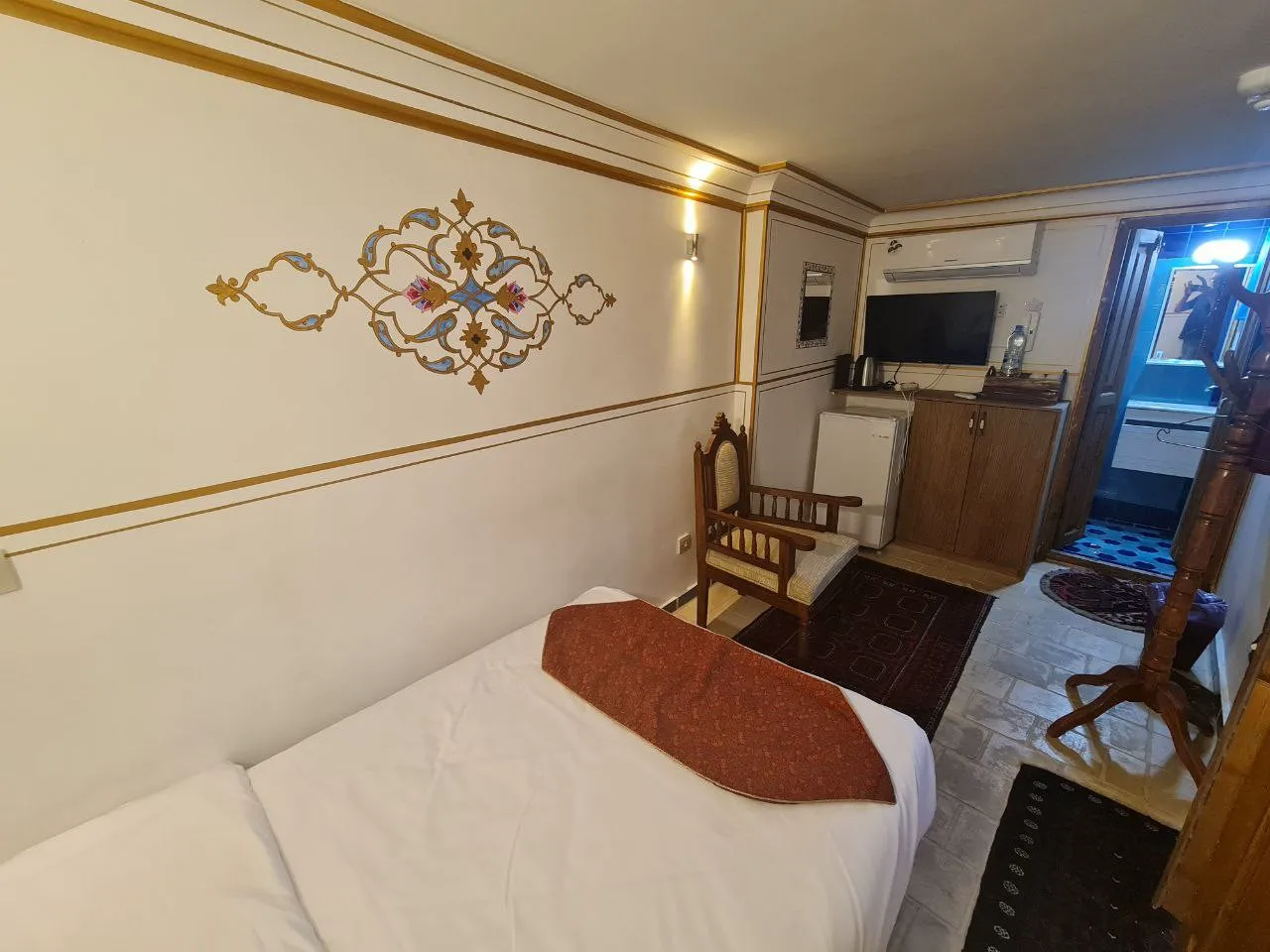 اتاق عمارت طاووسیه با تخت و تزیینات سنتی دیوار