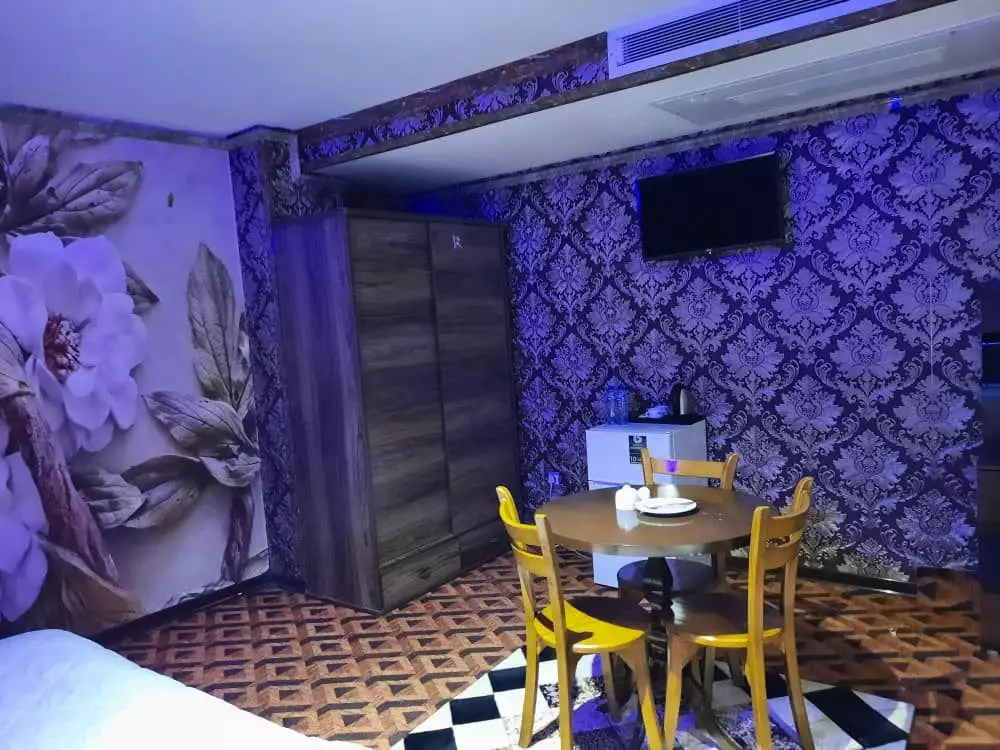 میز غذاخوری و دیوار گلدار اتاق هتل نگین پانیذ دنا