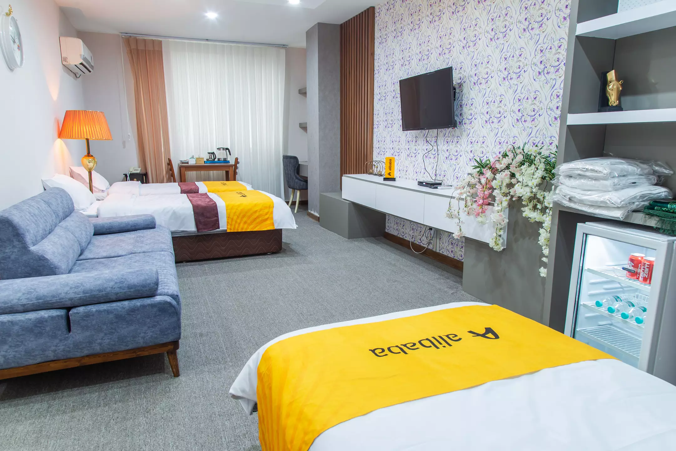 اتاق هتل سارینا با تخت، مبل و تلویزیون دیواری