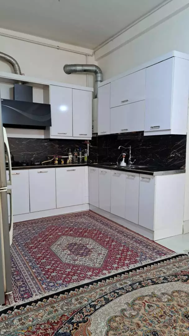 آشپزخانه با کابینت سفید و فرش ایرانی