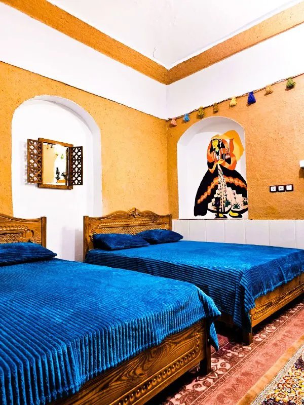 اتاق عمارت سرهنگ با دو تخت چوبی و روتختی آبی