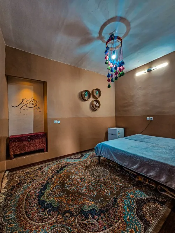اتاق عمارت سرهنگ با تخت آبی و فرش ایرانی