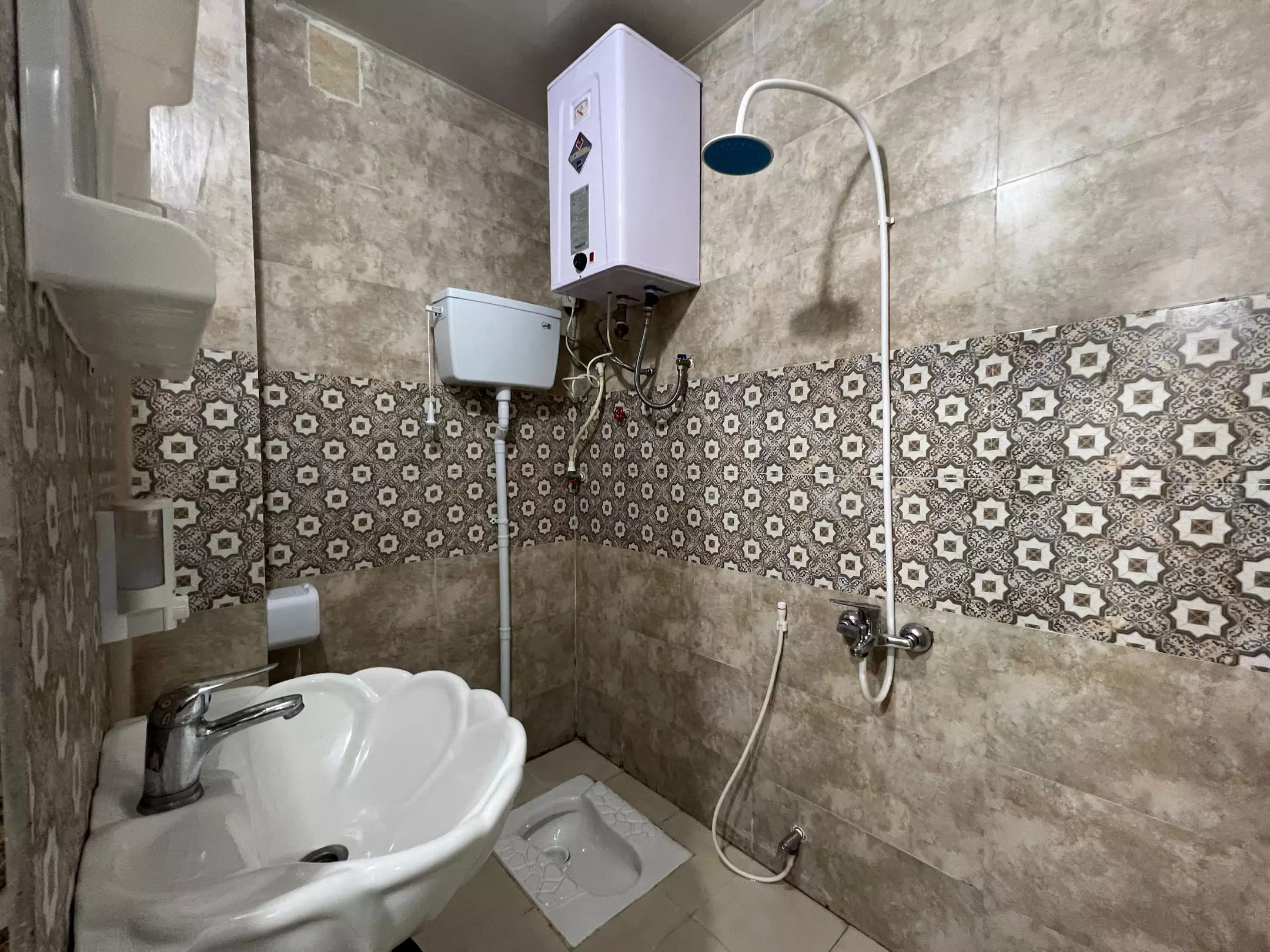 سینک و دوش حمام هتل میداف با کاشی طرح‌دار