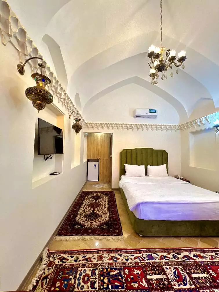 اتاق عمارت سهروردی با تخت دونفره و فرش ایرانی
