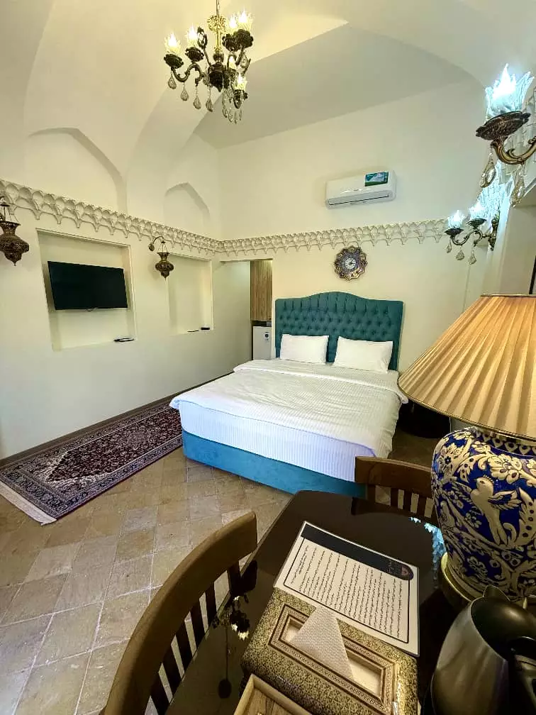 تخت دونفره و میز چوبی در اتاق عمارت سهروردی